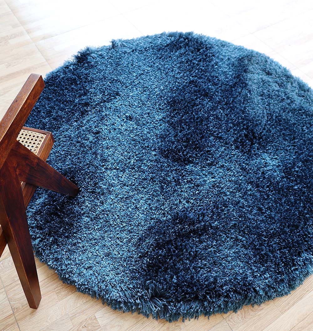 Angled top view clearly showcasing the irregular blue shaggy rug's modern design and luxurious, soft texture.