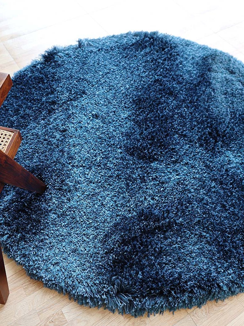 Angled top view clearly showcasing the irregular blue shaggy rug's modern design and luxurious, soft texture.