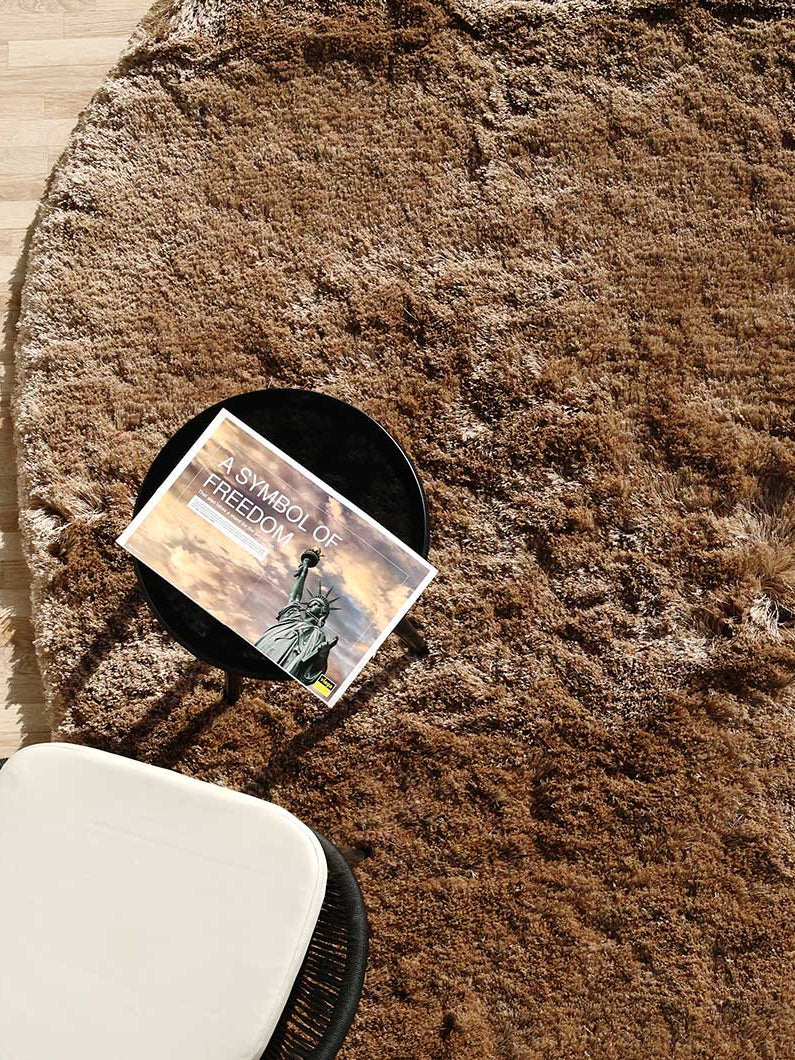 Side close-up of the irregular brown shaggy rug, clearly showing the thick plush texture and handmade construction.