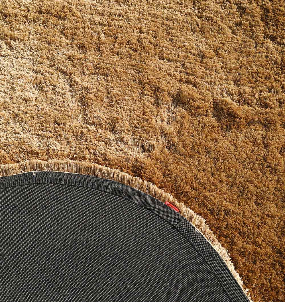 Backside of the irregular shaped brown plush rug, confirming the durable backing and expert construction.