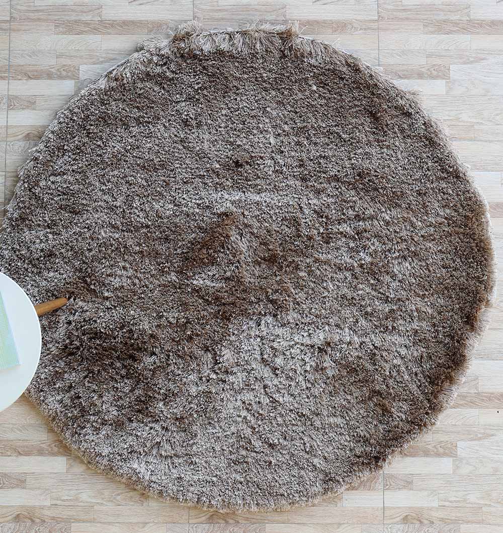 Top-down view of the brown shaggy rug in a perfect round shape, serving as a comfortable anchor for a living space.