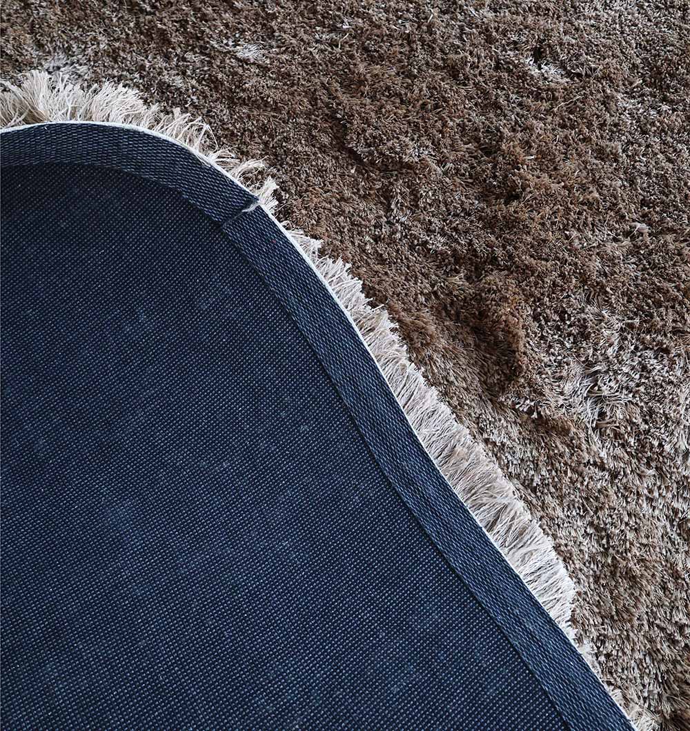 Close-up of the round shaggy rug's surface, highlighting the modern design and warmth provided by the plush texture.