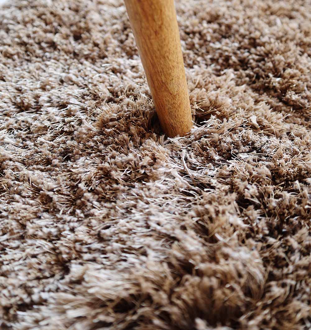 Close-up of the round shaggy rug's surface, highlighting the modern design and warmth provided by the plush texture.