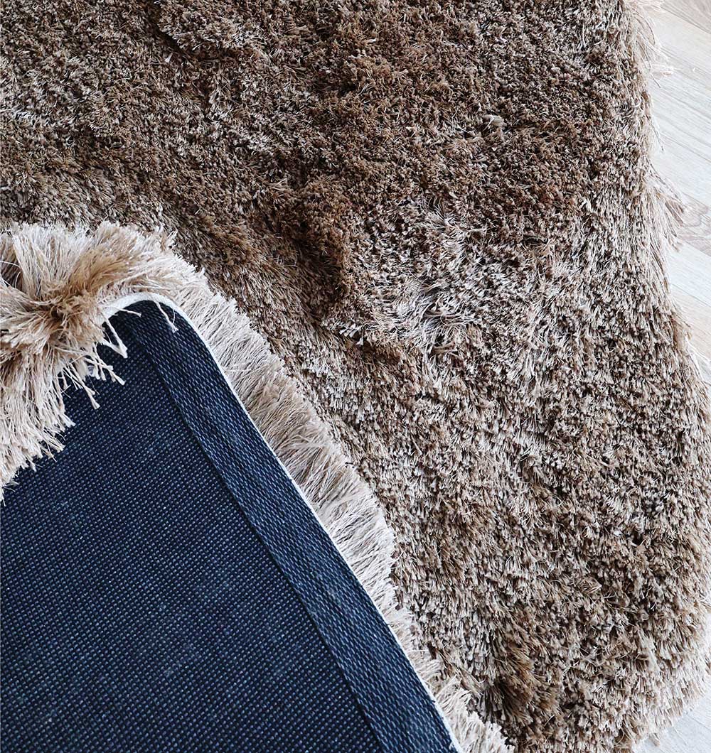 Backside of the irregular brown shaggy rug, confirming the durable handmade construction and quality backing.