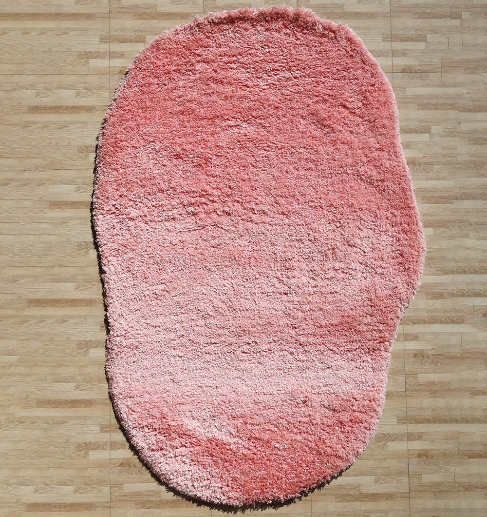 Irregular pink color plush rug, a modern shaggy design emphasizing unique shape, style, and comfort.