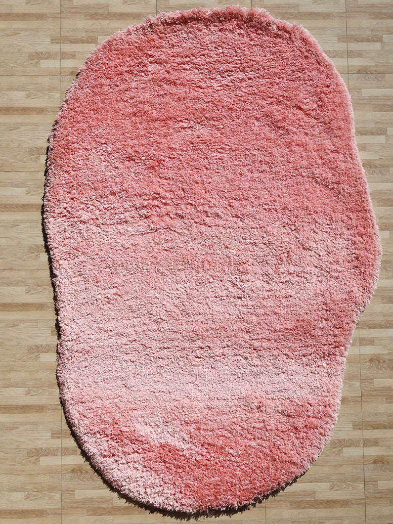 Irregular pink color plush rug, a modern shaggy design emphasizing unique shape, style, and comfort.