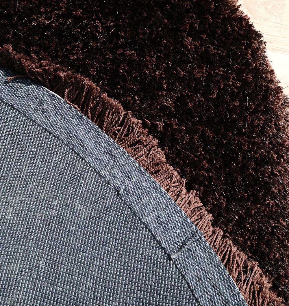Backside of the dark brown round shaggy rug, confirming the expert handmade construction and durable backing.