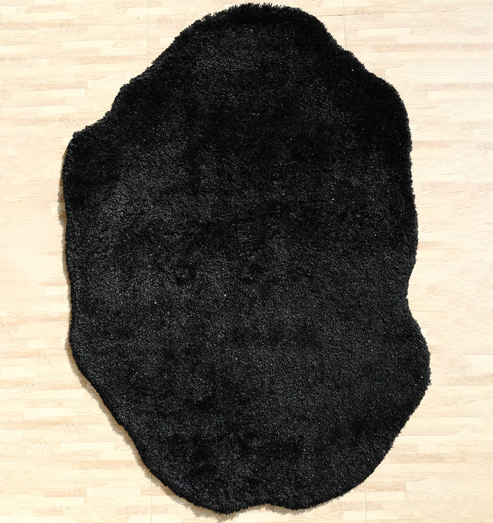 Thick shaggy irregular shape rug in black, a soft plush carpet adding modern sophistication to the room.