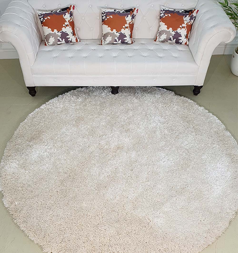 Solid grey circular shaggy rug placed in home decor, functioning as a neutral shading accent in the living room.