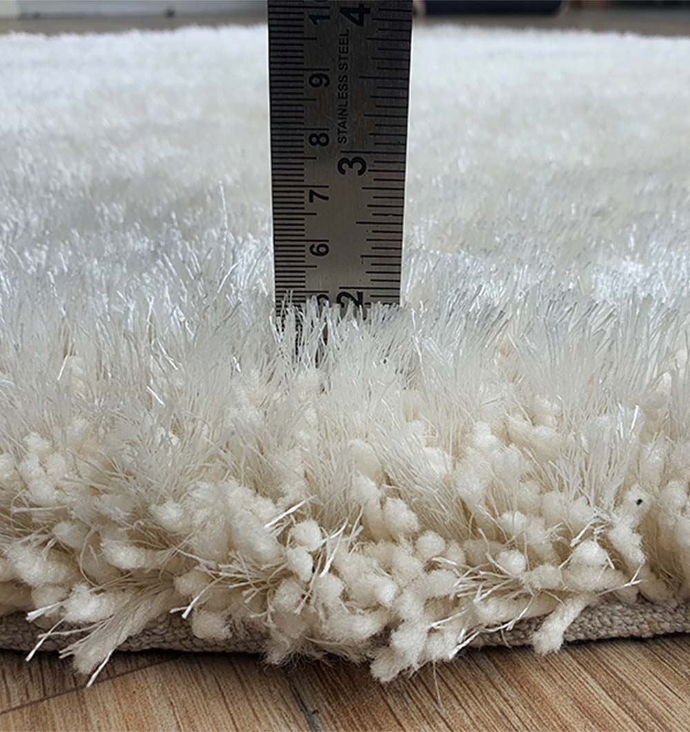 Solid grey circular shaggy rug placed in home decor, functioning as a neutral shading accent in the living room.