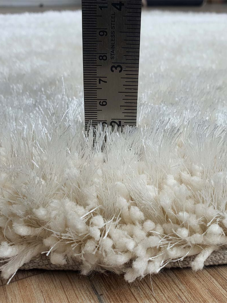 Solid grey circular shaggy rug placed in home decor, functioning as a neutral shading accent in the living room.