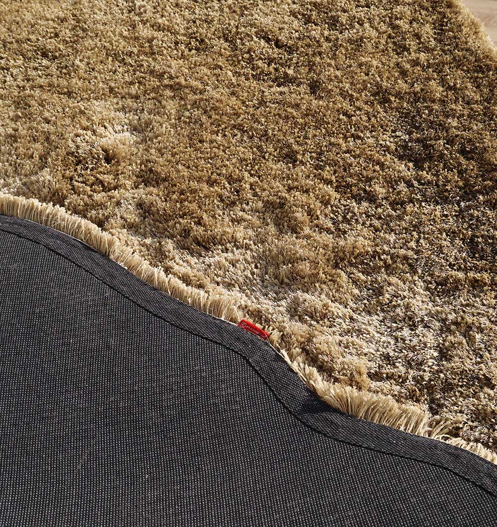 Backside of the irregular brown shaggy rug, confirming the durable backing and expert handmade construction.