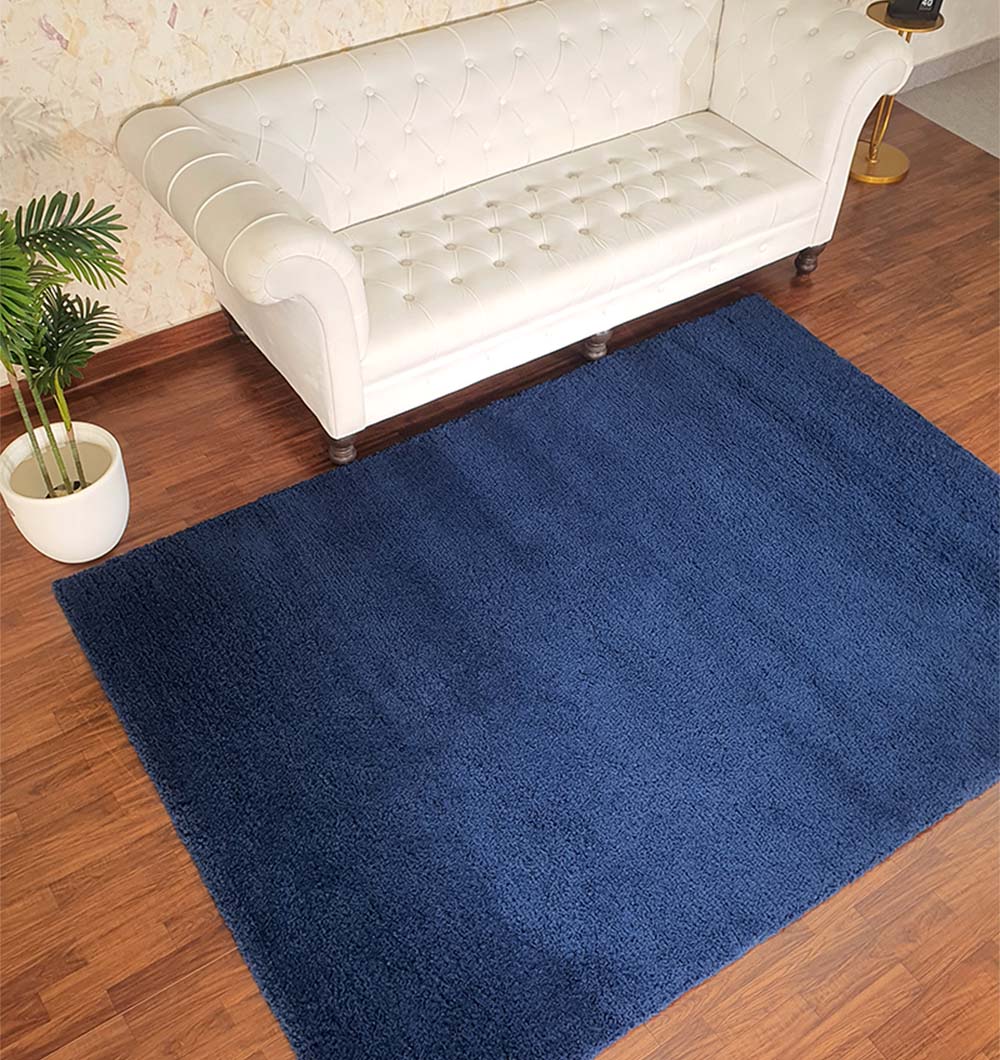 Navy blue handmade shaggy rug placed in a livingroom setting, adding a touch of luxury and warmth to the home decor.