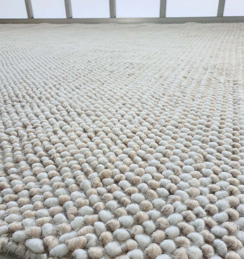 Close-up detailing the quality woven texture of the natural white rug, designed for lasting performance and contemporary style.