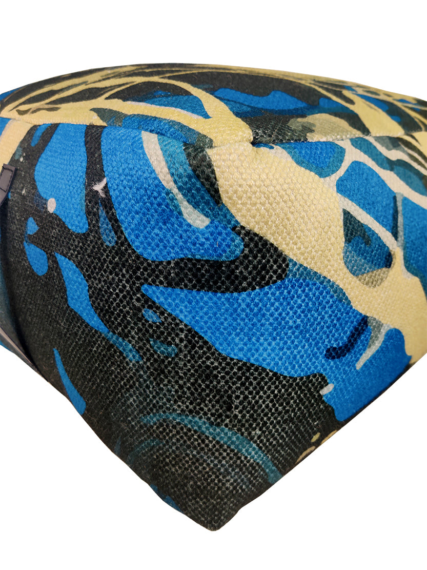 Handmade vibrant polyester pouf with handle, perfect for indoor or outdoor décor